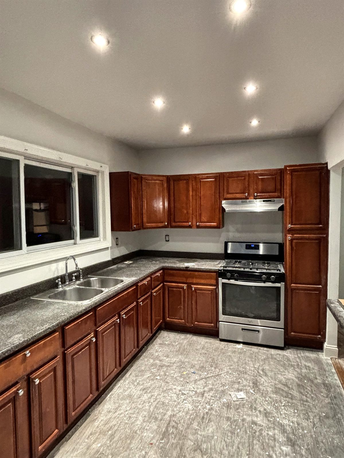 Kitchen with cherry cabinets, recessed lighting, and stainless range