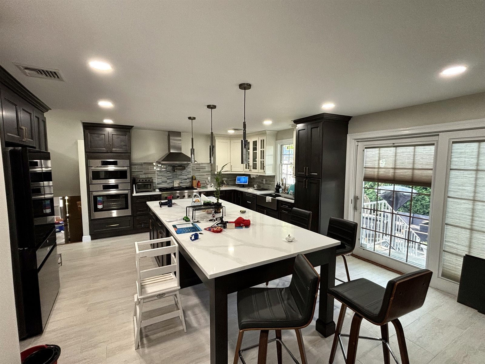Dark-cabinet kitchen with large quartz island and pendant lights