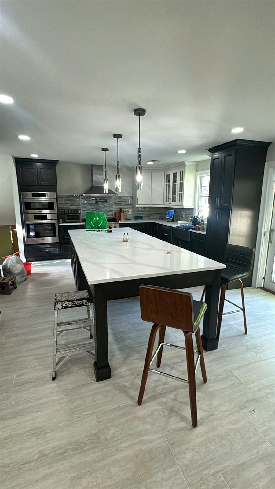Kitchen island with dark cabinets and quartz top during installation