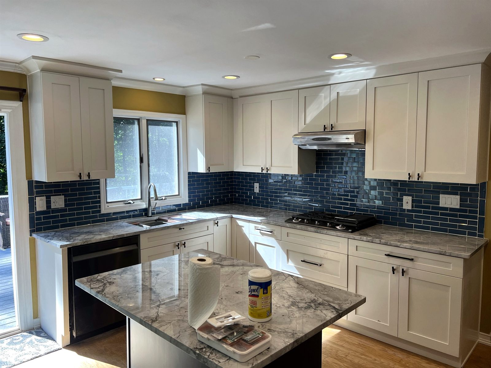 White shaker kitchen with blue glass subway backsplash